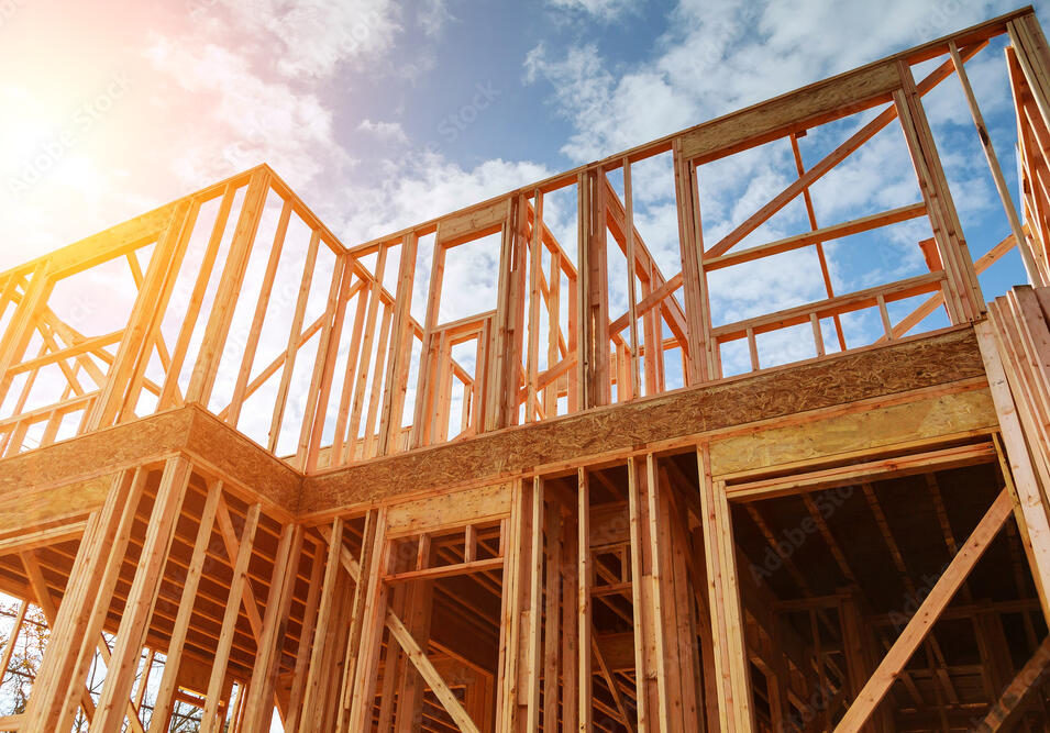 New housing is being built in front of a sunny backdrop.